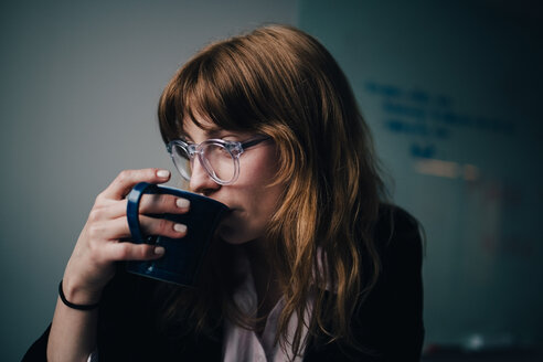 Junge Geschäftsfrau trinkt Kaffee im Kreativbüro - MASF08590