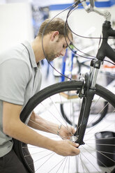 Junger Mann arbeitet an einem Fahrrad - CUF40132