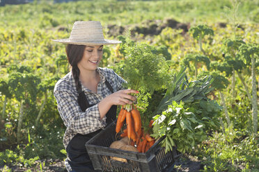 Young woman with vegetables grown at farm - CUF40145