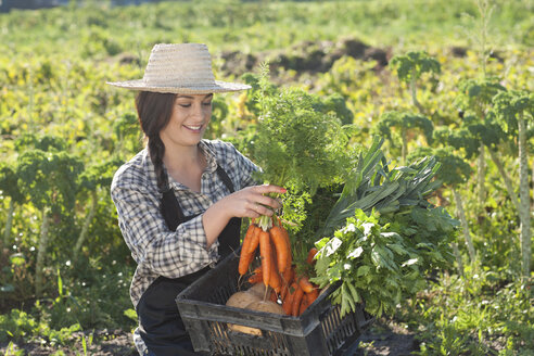 Junge Frau mit auf dem Bauernhof angebautem Gemüse - CUF40145