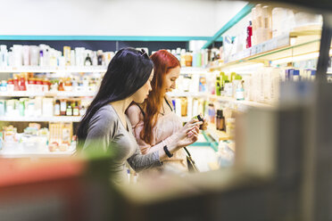 Zwei Frauen in einem Kosmetikgeschäft diskutieren über Produkte - WPEF00670