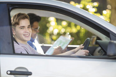 Porträt eines lächelnden Fahrschülers mit Ausbilder im Auto - ZEF15781