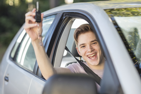 Happy learner driver cheering and holding car key stock photo