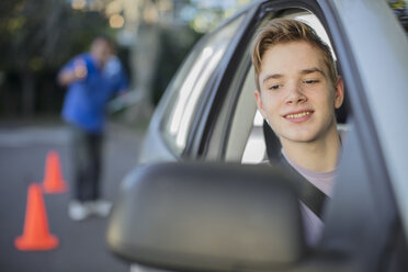 Fahrschüler, der das Fahren lernt, schaut in den Außenspiegel eines Autos - ZEF15799