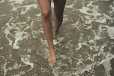 Legs of young woman wading in sea water - ACPF00104