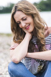 Portrait of smiling woman at the riverside - UUF14438