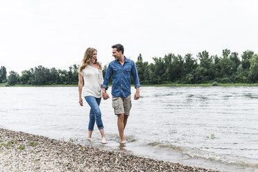 Happy couple wading in river - UUF14466