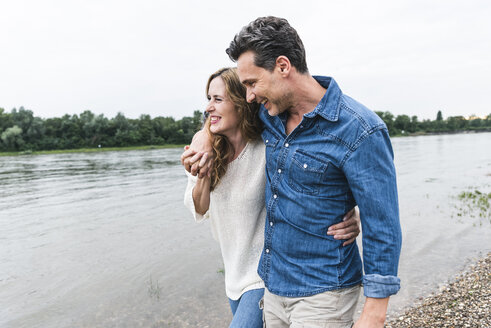Glückliches Paar bei einem Spaziergang am Flussufer - UUF14472