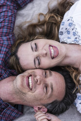 Happy playful couple lying on a blanket - UUF14531