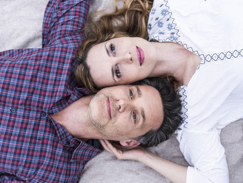 Portrait of affectionate couple lying on a blanket stock photo