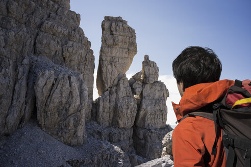 Kletterer schaut auf Felswände, Brenta-Dolomiten, Italien - CUF40365
