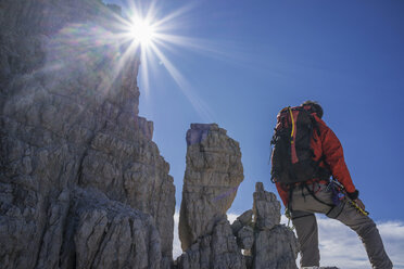 Climber looking at rocky walls, Brenta Dolomites, Italy - CUF40366