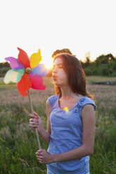 Girl blowing toy windmill - CUF40439