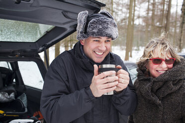 Mutter und Sohn bei einem heißen Getränk im Freien im Winter - CUF40444