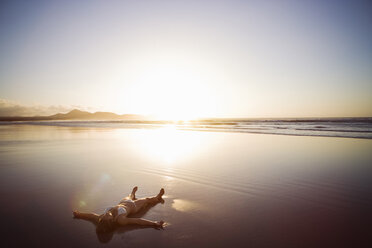 Woman lying on beach, Lanzarote, Canary Islands, Spain - CUF40468