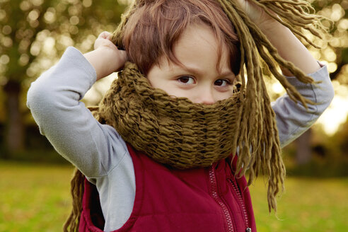 Boy in park, with scarf covering mouth - CUF40526