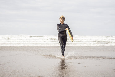 Ältere Bodyboarderin paddelt an der Küste von Devon, UK - CUF40556