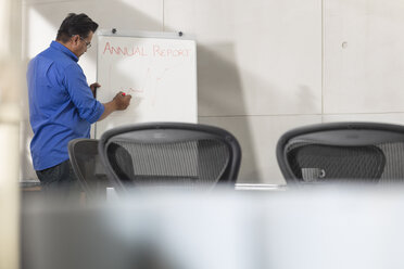 Geschäftsmann schreibt auf Whiteboard in Konferenzraum - ZEF15807