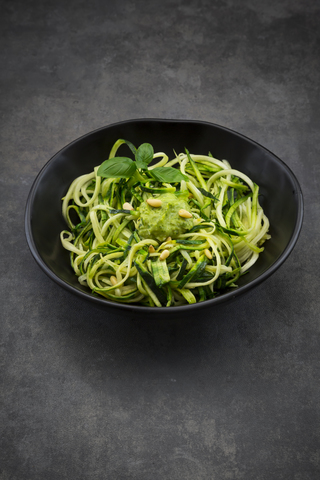 Bowl of Zoodels with avocado basil pesto stock photo