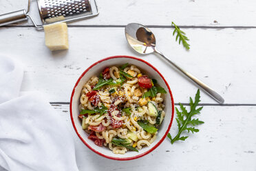 Schüssel Nudelsalat mit Mais, Gurken, Tomaten, Rucola und geriebenem Parmesan - SARF03824