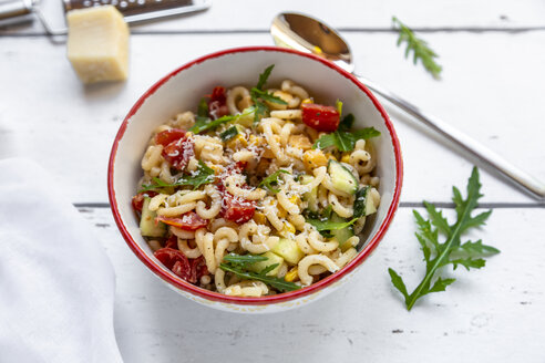 Schüssel Nudelsalat mit Mais, Gurken, Tomaten, Rucola und geriebenem Parmesan - SARF03825