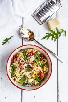 Bowl of noodle salad with corn, cucumber, tomatoes, rocket and grated parmesan - SARF03826