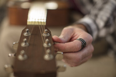 Nahaufnahme einer Männerhand, die eine Gitarre stimmt - ZEF15817