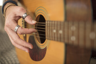 Nahaufnahme einer Männerhand beim Gitarrenspiel - ZEF15822