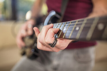Nahaufnahme der Hand eines Mannes beim Spielen einer E-Gitarre - ZEF15831