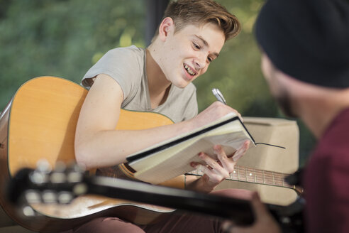 Musiker unterrichtet Schüler im Gitarrenspiel - ZEF15835