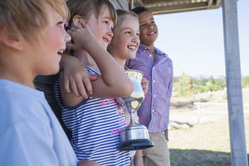 Vier Kinder mit Trophäe, die wegschauen - CUF40798