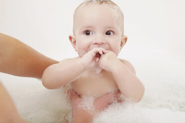 Mother washing baby girl in bubble bath - CUF40880