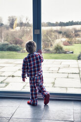 Junge im Pyjama schaut aus dem Fenster - CUF40892