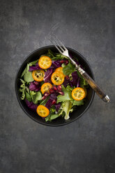 Bowl of mixed green salad with red cabbage, kumquat and pomegranate seeds - LVF07260