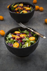 Bowl of mixed green salad with red cabbage, kumquat and pomegranate seeds - LVF07262