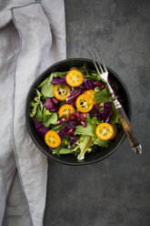 Bowl of mixed green salad with red cabbage, kumquat and pomegranate seeds - LVF07264