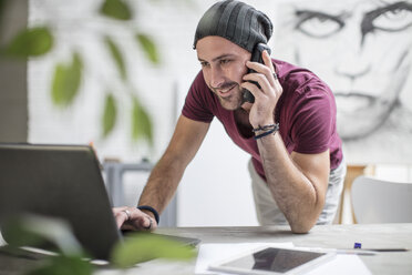 Künstlerin mit Laptop und Mobiltelefon im Atelier - ZEF15846