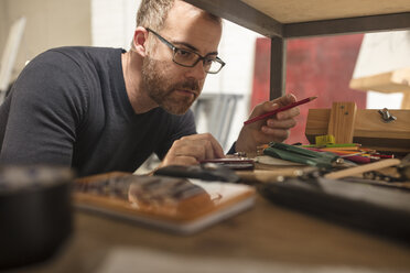 Mann im Atelier eines Künstlers, der seine Vorräte überprüft - ZEF15881