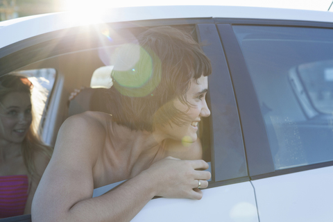 Frau schaut über die Schulter durch das Autofenster, lizenzfreies Stockfoto