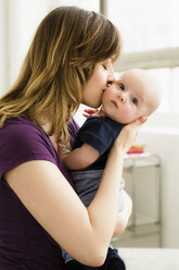 Mother kissing baby son on cheek - CUF41277