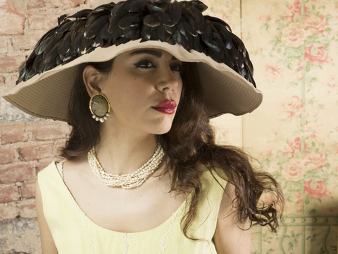 Porträt einer Frau mit breitkrempigem Hut mit Federn, lizenzfreies Stockfoto