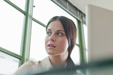 Young female office worker looking out of window - CUF41447