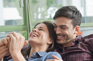 Romantic young couple laughing on sofa - CUF41486