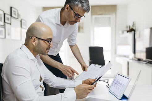 Two colleagues working at home with tablet and documents - JRFF01686