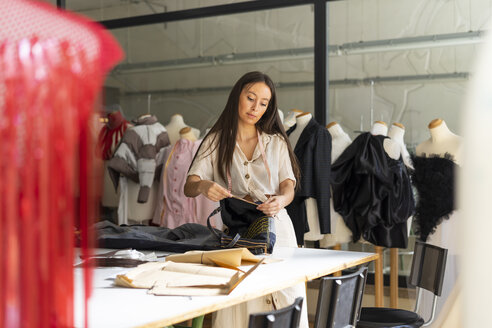 Junge Modedesignerin bei der Arbeit in ihrem Atelier - AFVF00750