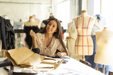 Junge Modedesignerin bei der Arbeit in ihrem Atelier - AFVF00752