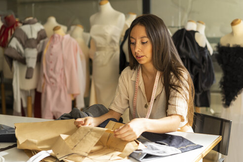 Junge Modedesignerin bei der Arbeit in ihrem Atelier - AFVF00753