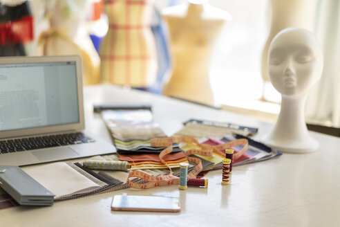 Näharbeiten auf dem Arbeitstisch im Atelier einer Modedesignerin - AFVF00760