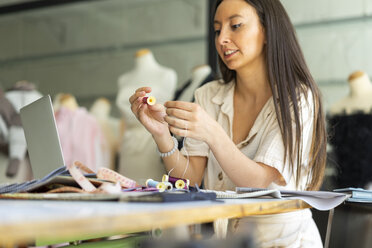 Junge Modedesignerin bei der Arbeit in ihrem Atelier - AFVF00761