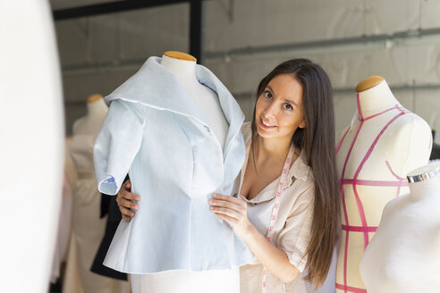 Junge Modedesignerin bei der Anprobe von Kleidern an einem Schneidermodell - AFVF00764